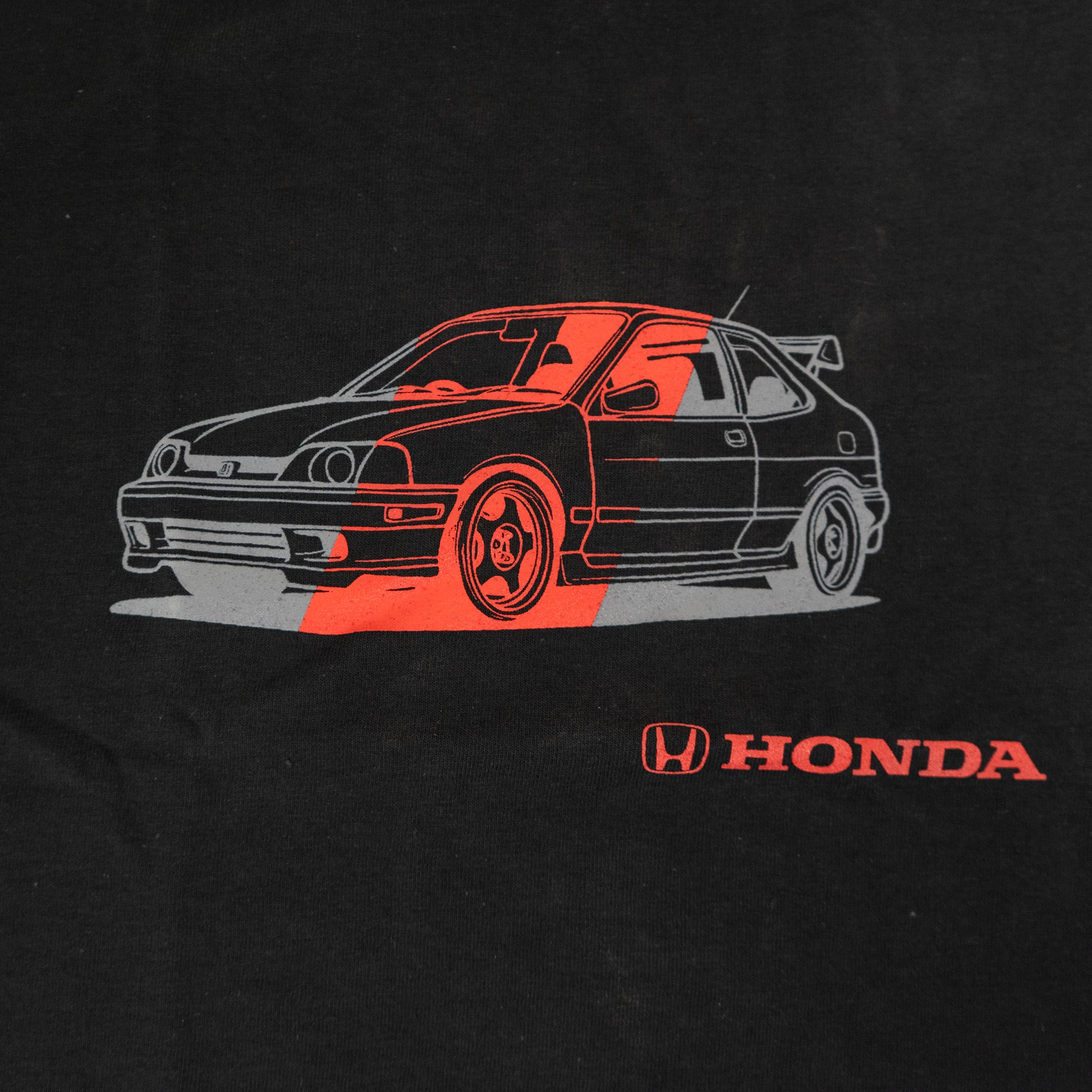 Black t-shirt with red and white car graphic and Honda logo on a black background