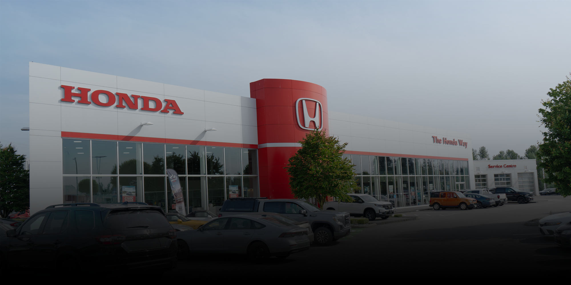 Honda dealership building with cars parked in front